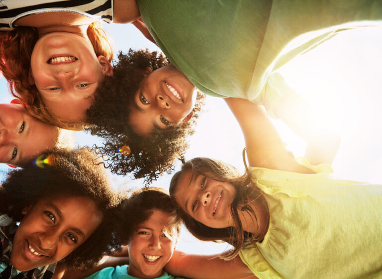 Happy, huddle and portrait of kids in park for bonding, playing and fun together outdoors. Diversity, youth and low angle of children hug in circle for childhood, friendship and relax on weekend Happy, huddle and portrait of kids in park for bonding, playing and fun together outdoors. Diversity, youth and low angle of children hug in circle for childhood, friendship and relax on weekend.